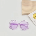 Detail of purple flower-shaped sunglasses for kids with clear frames on a white background - Amethyst