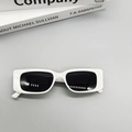 Vista superior detallada de gafas de sol blancas rectangulares sobre libros de moda - Blanco Porcelana