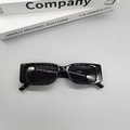 Primer plano de gafas de sol rectangulares negras vintage sobre libros de decoración - Negro