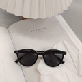 Detailansicht der schwarzen TR90 Kinder-Sonnenbrille auf einem Magazin bei warmem Licht - Schwarz