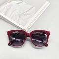 Detalle de gafas de sol ovaladas color burdeos con lentes degradadas en una revista de moda - Rojo Oscuro