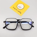 Close-up of kids' black square frame glasses with anti-blue light lenses and yellow card - Black Frame Clear Lenses
