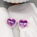 Vue détaillée de lunettes de soleil cœur rose avec verres dégradés violets sur chemise - Rose