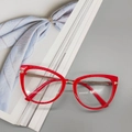 Detailansicht der roten Cateye-Brille mit eleganten goldenen Metallbügeln und Feder - Gelee-Orange