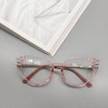 Detail der rosa TR90-Cateye-Brille mit gewelltem Rand auf einem Modemagazin - Transparentes Rosa