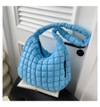 Detail of light blue quilted puff bag showing soft puffy texture and wide shoulder strap - Blue