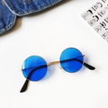Detail shot of vintage round blue lens sunglasses with gold metal frame on white surface - Ocean Blue