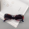 Oval retro sunglasses featuring a colorful artistic floral frame and dark grey lenses - Anagallis