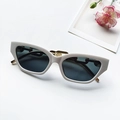 Chique crème cat-eye zonnebril met donkergrijze glazen en gouden kettingdetail - Wit