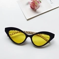 Trendy women's cat-eye sunglasses with vibrant yellow lenses and gold chain link detail - Black Frame Yellow Lens