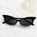 Occhiali da sole cat-eye neri classici con montatura lucida su sfondo in tessuto bianco - Nero