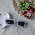 Detail of white rectangular sunglasses with unique wavy textured frames and dark lenses - White