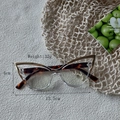 Cat eye glasses frame detail with tortoise shell patterns and metal trim dimensions - Clear