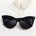 Chic black triangle cat-eye sunglasses with silver accents on white textured fabric - Black
