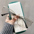 Detail der silbernen geometrischen Brille mit grünem Samtetui und Metallscharnieren - Silberner Rahmen Hellgrau
