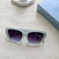 Détail de lunettes de soleil vert menthe mat avec verres dégradés violets sur tissu - Bleu ciel