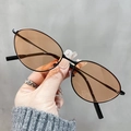 Dettaglio degli occhiali da sole vintage cat-eye con montatura in metallo nero e lenti marroni - Marrone Nero