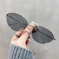 Dettaglio di occhiali da sole vintage ovali con montatura in metallo argento e lenti scure - Grigio chiaro