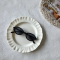 Gafas de sol ovaladas negras retro con lentes oscuras y estilo minimalista en un plato - Negro y Gris