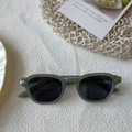 Vintage olive green sunglasses with gold studs and dark lenses on a neutral fabric - Green