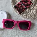 Modieuze fuchsia chunky cat-eye zonnebril met donkere glazen op een gestructureerde basis - Rozerood