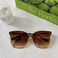Close-up of baby sunglasses with metal frames and brown gradient lenses on textured surface - Brown