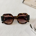 Detailed macro view of octagonal tortoiseshell sunglasses with black accent frames - Tortoise Brown
