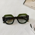 Dettaglio di occhiali da sole tondi bicolore con montatura verde e nera su tessuto - Montatura Nera Lente Verde