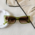 Detail of square green translucent sunglasses with brown gradient lenses on a tray - Transparent Green