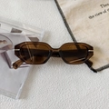 Detailed close-up of amber textured small frame sunglasses with silver metal hinge accents - Transparent Dark Tea