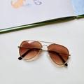 Detail of kids pilot sunglasses with gold metal frame and brown gradient lenses - Brown