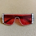 Détail de lunettes de soleil rouges oversize avec strass en cristal sur tissu texturé - Rouge