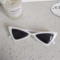 Nahaufnahme der Retro-Kindersonnenbrille in Weiß mit schwarzen Gläsern auf Struktur - Off-White Grau