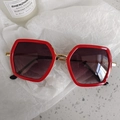 Gafas de sol rojas hexagonales para niños con puente dorado sobre papel blanco - Estilo Hexagonal