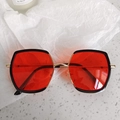 Detail of red lenses with black frames and gold metal hinges on trendy kids sunglasses - Side Square Frame Style