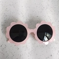 Close-up of light pink flower-shaped sunglasses for kids with dark circular lenses - Jelly Pink