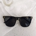 Détail de lunettes de soleil noires avec logo D en métal doré sur la branche - Style de lettre (DD)