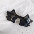 Detailed view of star-shaped sunglasses with black frame and silver glitter accents - Black