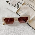 Détail de lunettes de soleil à monture crème avec verres bruns et accents dorés - Blanc Gelée