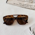 Detailed close-up of tortoiseshell double-bridge sunglasses on a stylish canvas backdrop - Tortoiseshell Dark Tea