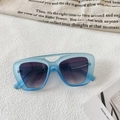 Detail of blue matte frame sunglasses with purple gradient lenses and hollow bridge design - Transparent Blue