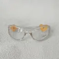 Détail de lunettes transparentes avec trèfle jaune et cœur, verres avec protection UV400 - Thé Clair / Lentille Claire