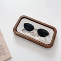 Detailed shot of oval metal sunglasses with black lenses on a rustic wooden tray - Silver Grey