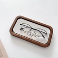 Vue détaillée de lunettes de soleil ovales en métal noir sur plateau avec plaquettes en silicone - Monture Noire Verres Transparents