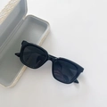 Detailed close-up of kids black square sunglasses with a cream woven texture case - Black