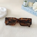 Detailaufnahme einer Vintage-Rechteck-Sonnenbrille mit Schildpattmuster auf weißem Grund - Leopardenmuster