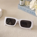 Minimalistische weiße quadratische Sonnenbrille auf einem Buch mit weißen Rosen und Serum - Porzellanweiß