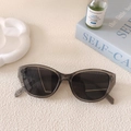 Chic cat-eye sunglasses with translucent grey frames and dark lenses on a neutral surface - Transparent Grey Frame Grey Lens