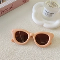 Nahaufnahme der Retro Kinder Sonnenbrille in Rosa mit Katzenaugen Form auf weißem Grund - Rosa