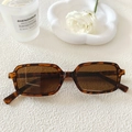 Vue détaillée de lunettes de soleil carrées en écaille brune sur fond blanc - Monture Écaille Verres Thé